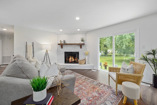 a white living room with a fireplace, large sliding glass door and a grey couch